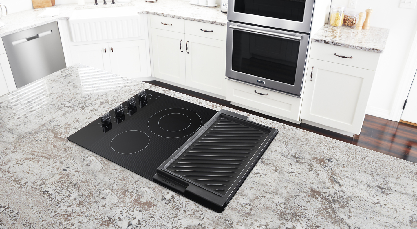 Electric stovetop with built-in griddle on granite island countertop
