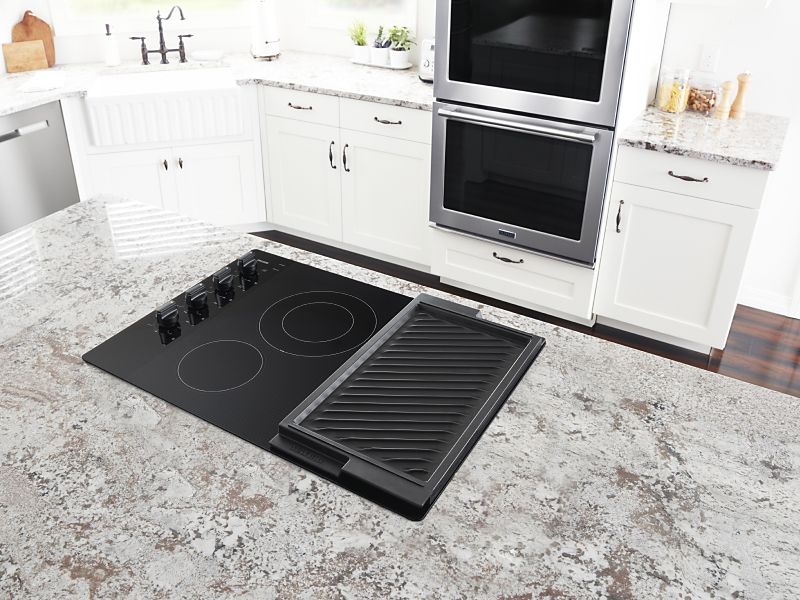 Electric stovetop with built-in griddle on granite island countertop
