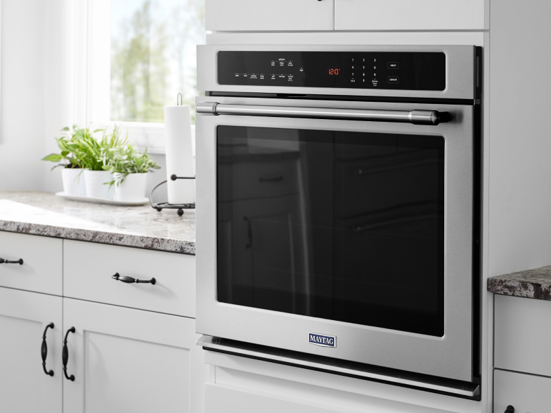 Stainless steel single wall oven from Maytag brand in white cabinetry