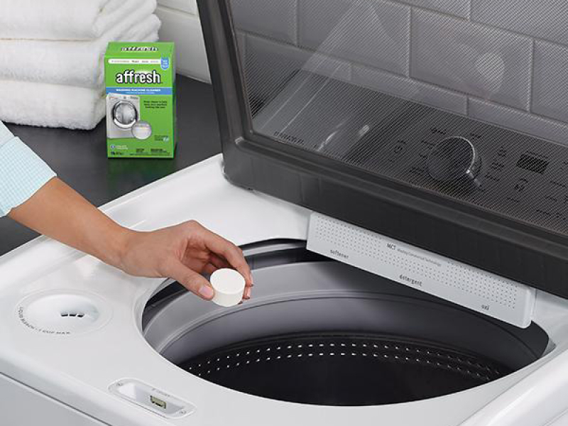 Person using affresh® tablet in washing machine