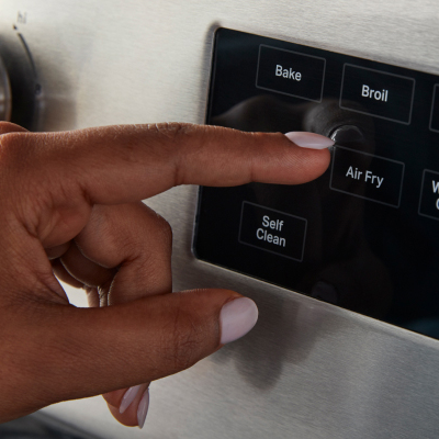 Person pressing air fry button on the oven