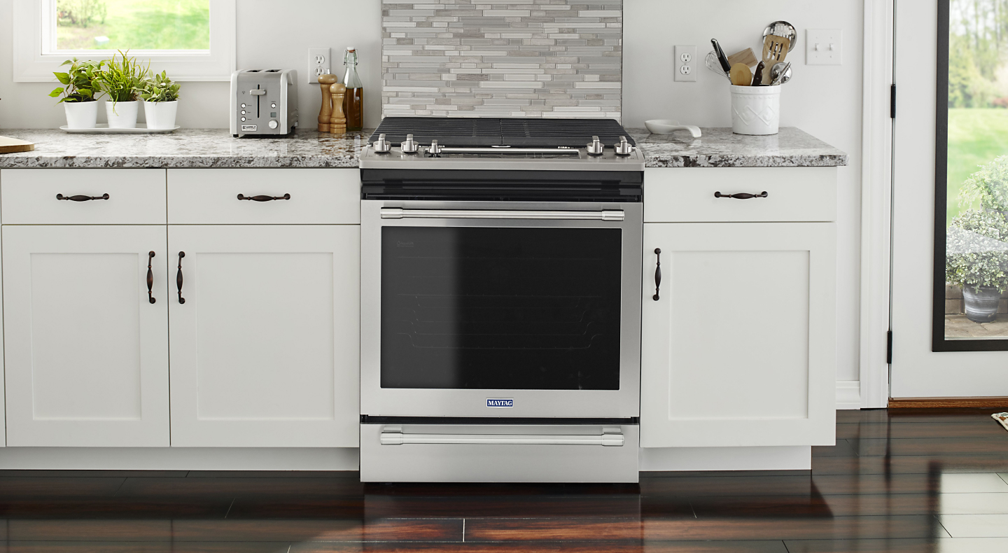 A stainless steel oven surrounded by white cabinetry