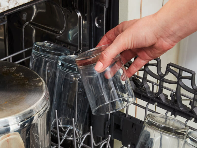 Loading a glass into the dishwasher