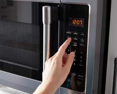 A finger making a selection on a microwave