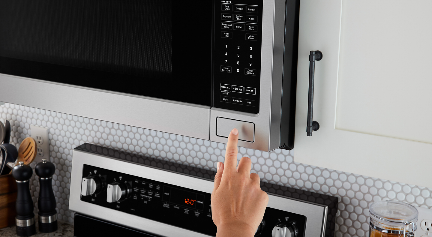 A finger making a selection on a Maytag® microwave