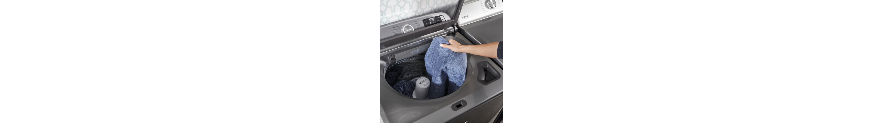 Person loading clothes into Maytag® top load washer 