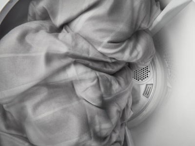 Gray blanket tumbling inside of dryer