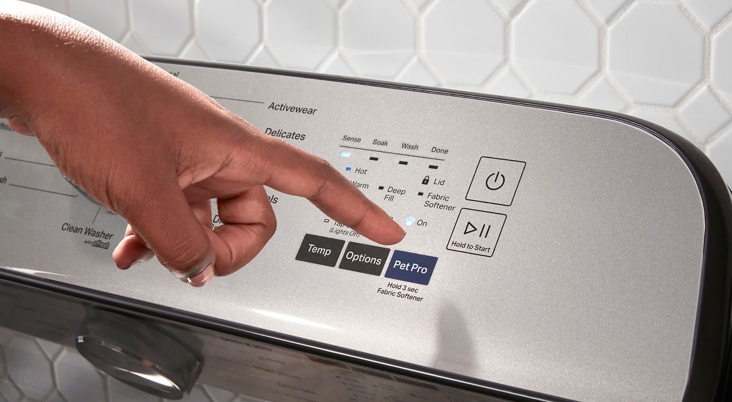 Person pressing Pet Pro button on washer