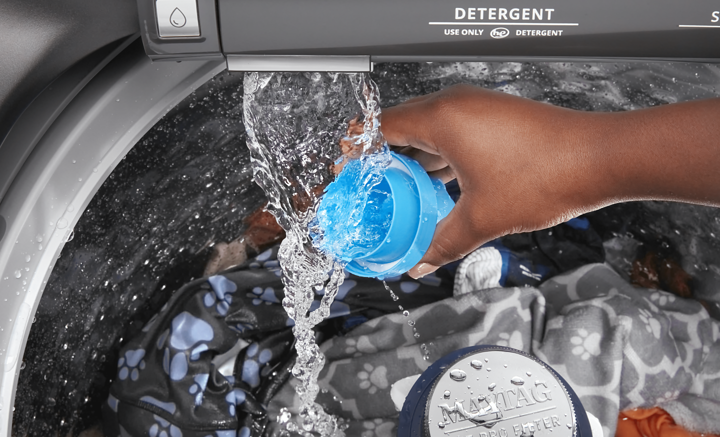 Person adding detergent to a top loading Maytag® washing machine