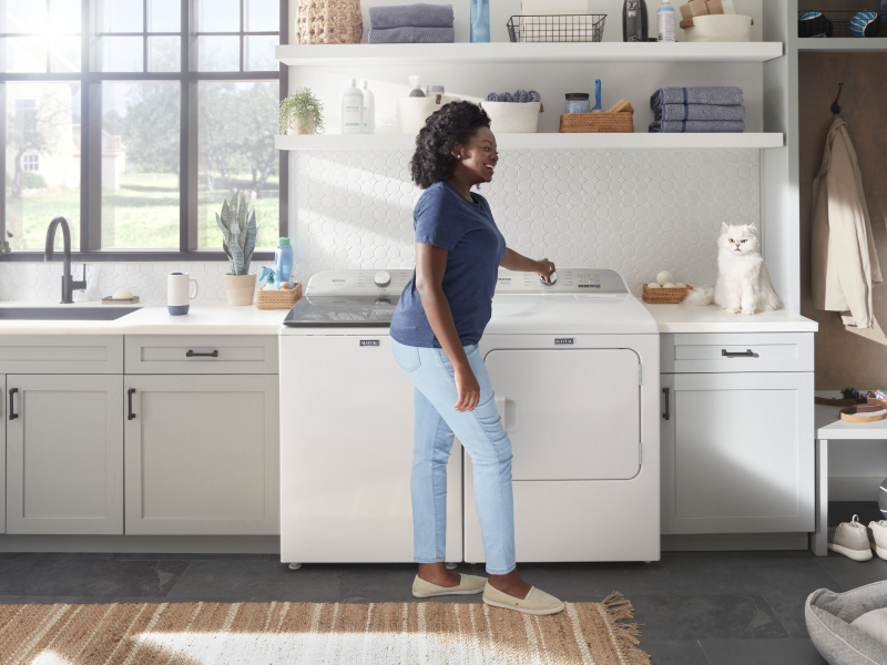Person loading a Maytag® Washer.