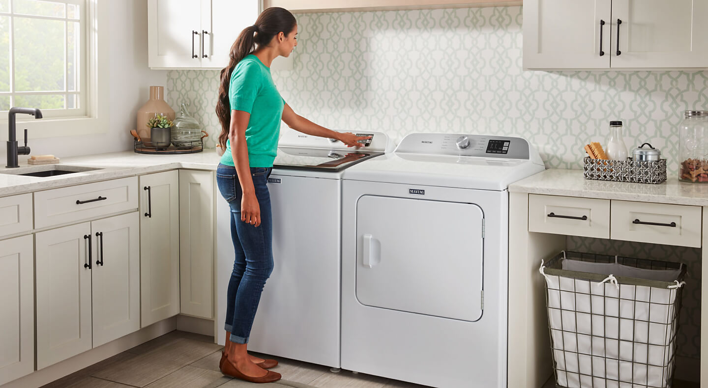 Person selecting a setting on a washing machine