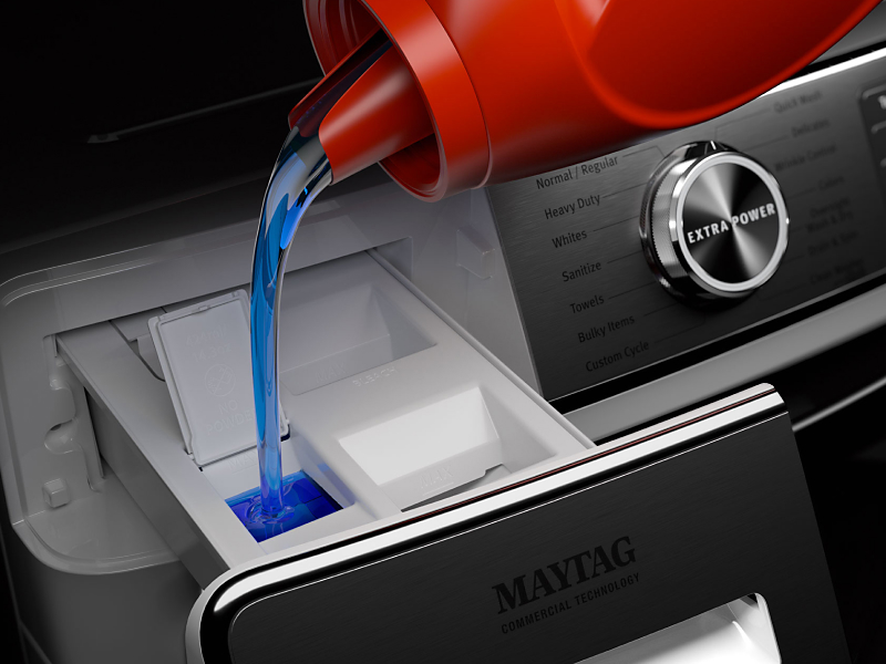 Close-up of bottle pouring detergent into detergent dispenser on Maytag® front load washer