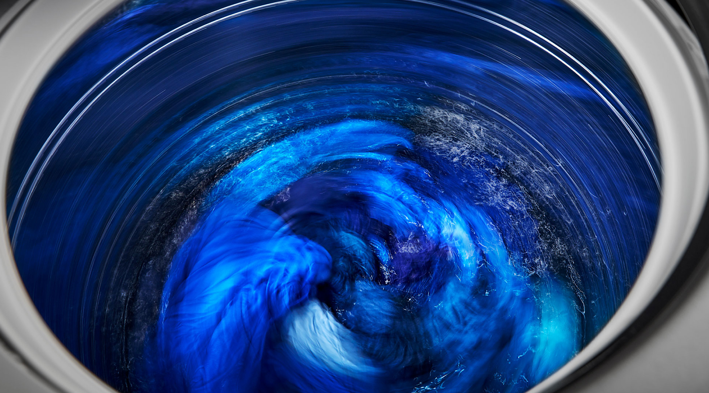 Close-up of blue clothes spinning inside washing machine