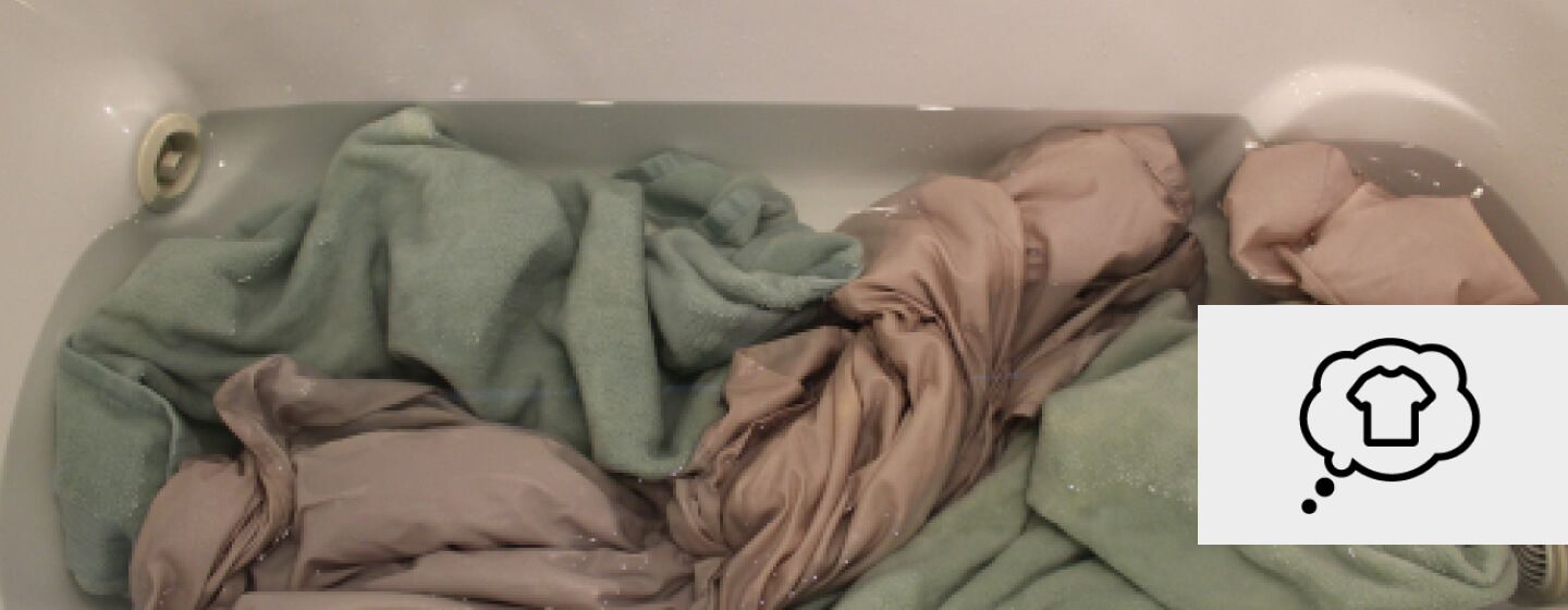 Sheets and towels soaking in a bathtub
