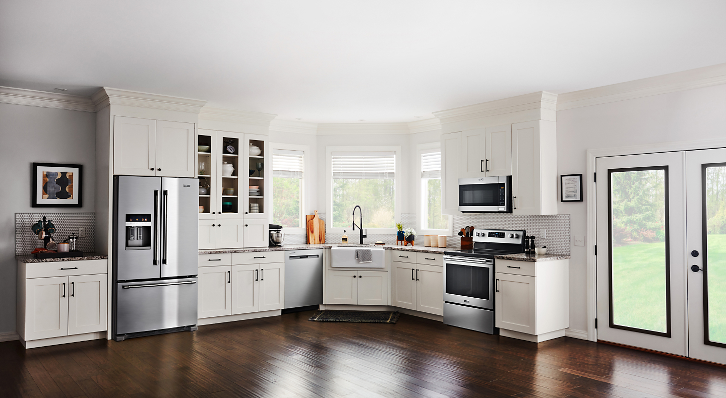 Open kitchen with white cabinetry and stainless steel French door refrigerator