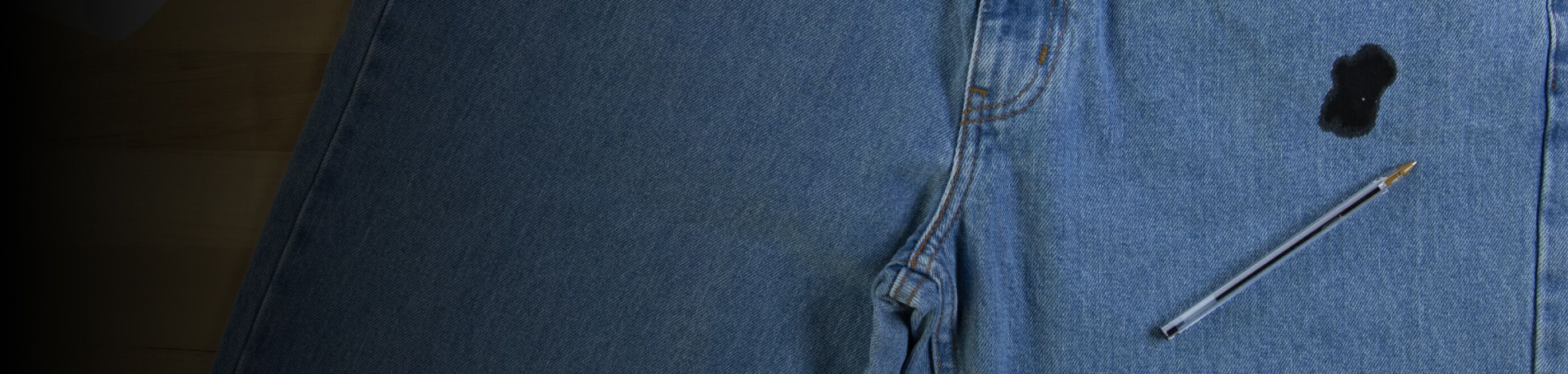 A pen on a pair of jeans stained with ink