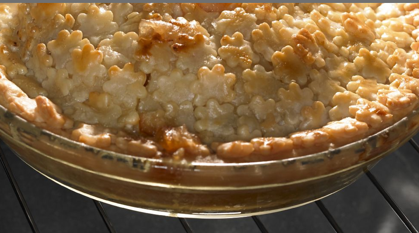 A close up of pie crust on an oven rack.