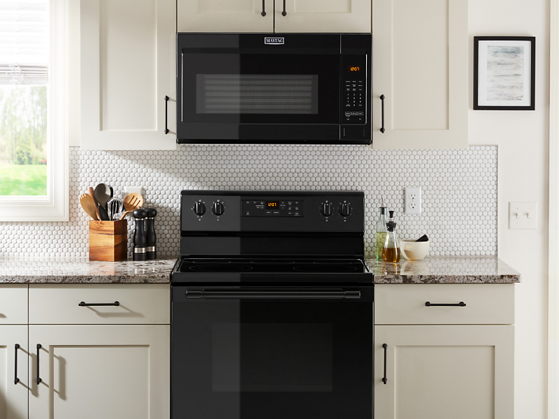 Steam escaping a pot on a gas range under a Maytag® over-the-range microwave