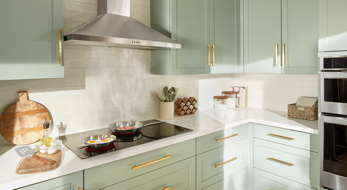 Eggs and bacon frying on a cooktop with a stainless steel range hood Eggs and bacon frying on a cooktop with a stainless steel range hood