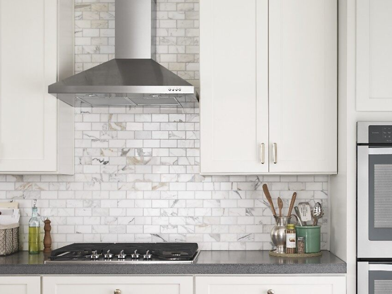 Stainless steel Maytag® range hood in a bright kitchen