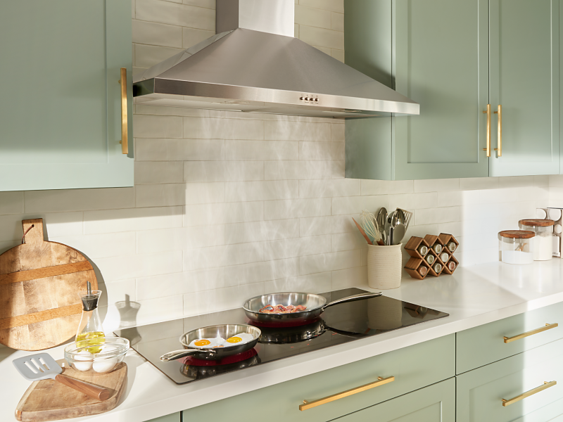 Stainless steel Maytag® range hood in a light green kitchen Stainless steel Maytag® range hood in a light green kitchen