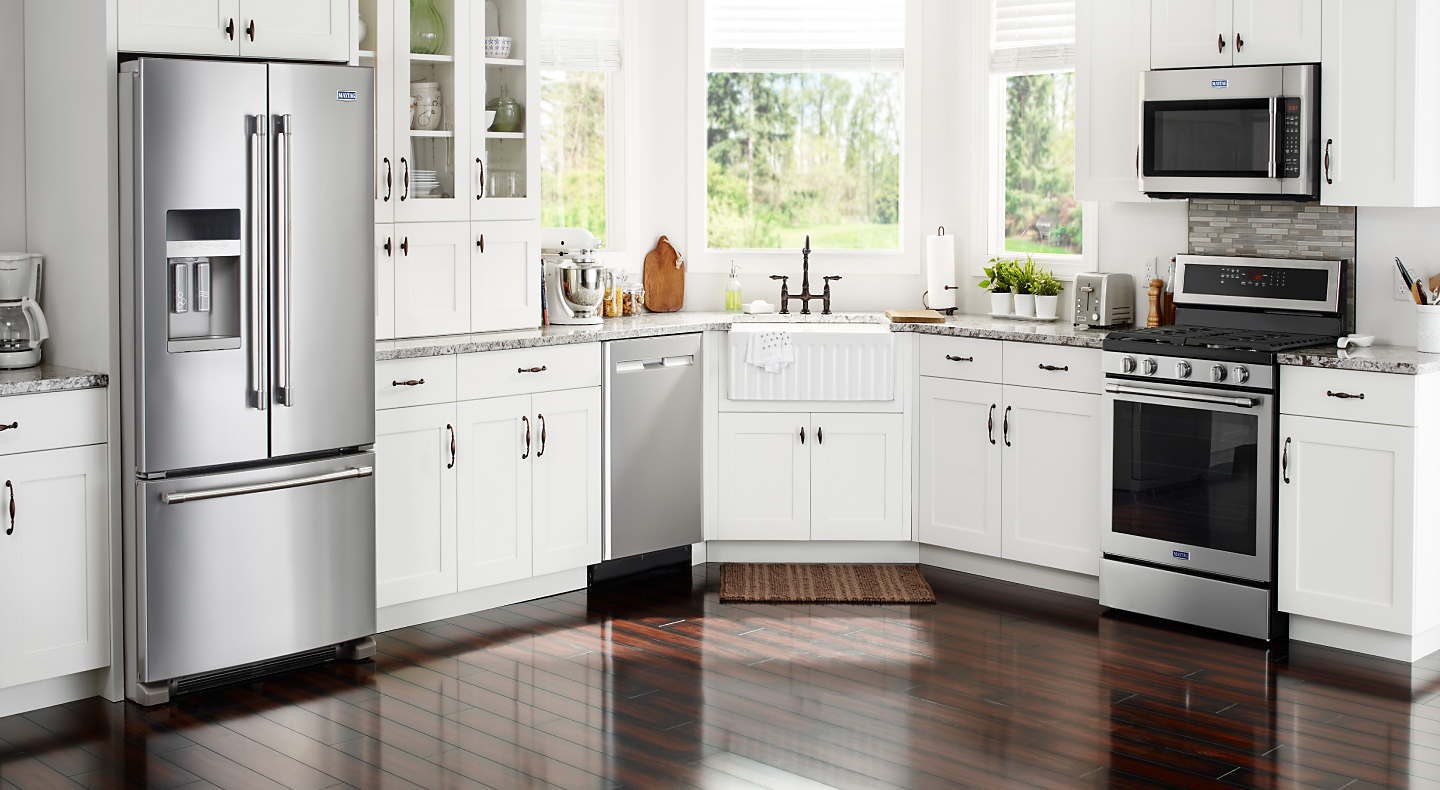 Various stainless steel appliances in a modern kitchen with white cabinetry Various stainless steel appliances in a modern kitchen with white cabinetry