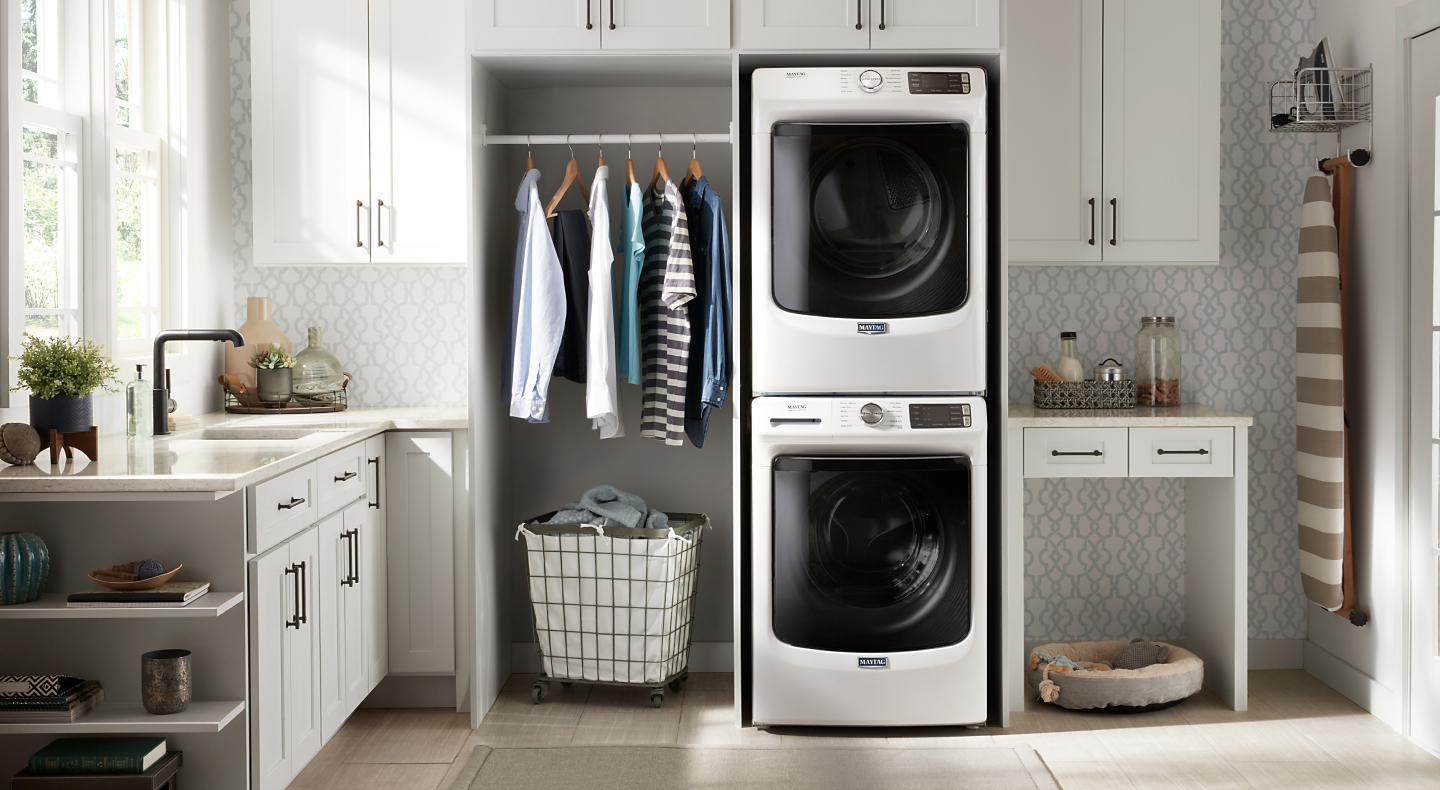 White Maytag® stacked washer and dryer in a laundry room