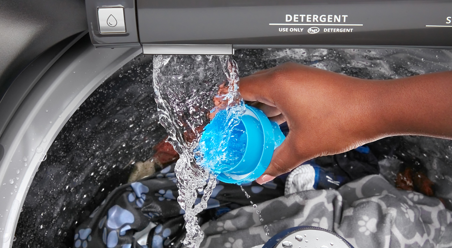 Person adding detergent to a top load Maytag® washer