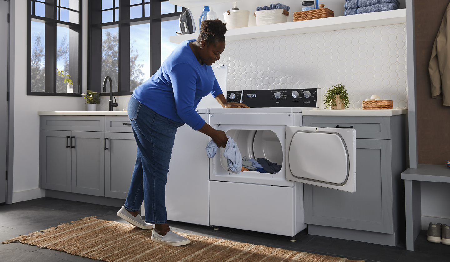 Person unloading laundry from a Maytag® dryer