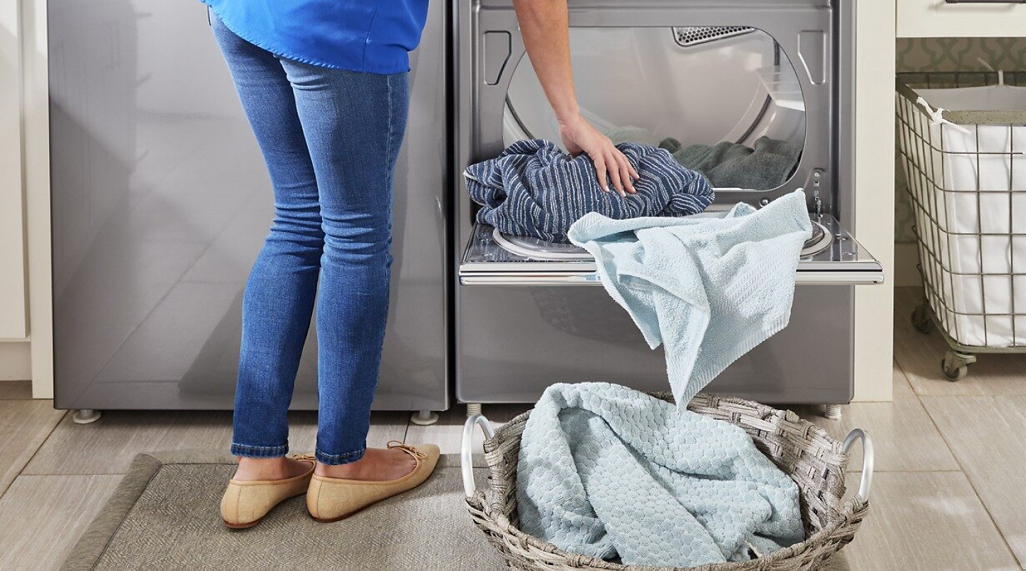 Woman unloading towels from the dryer