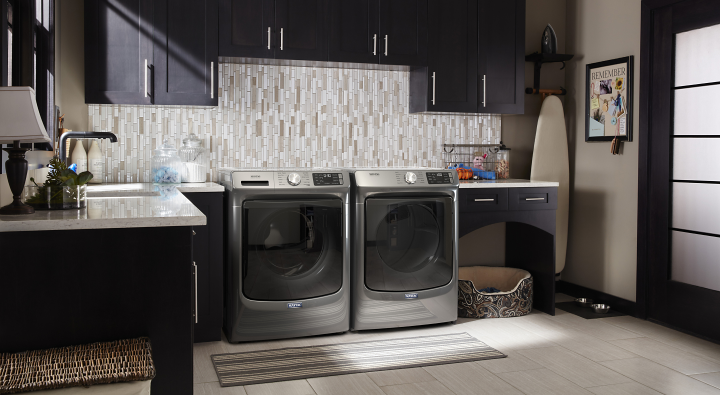 Maytag® front load washer and dryer set in a modern laundry room