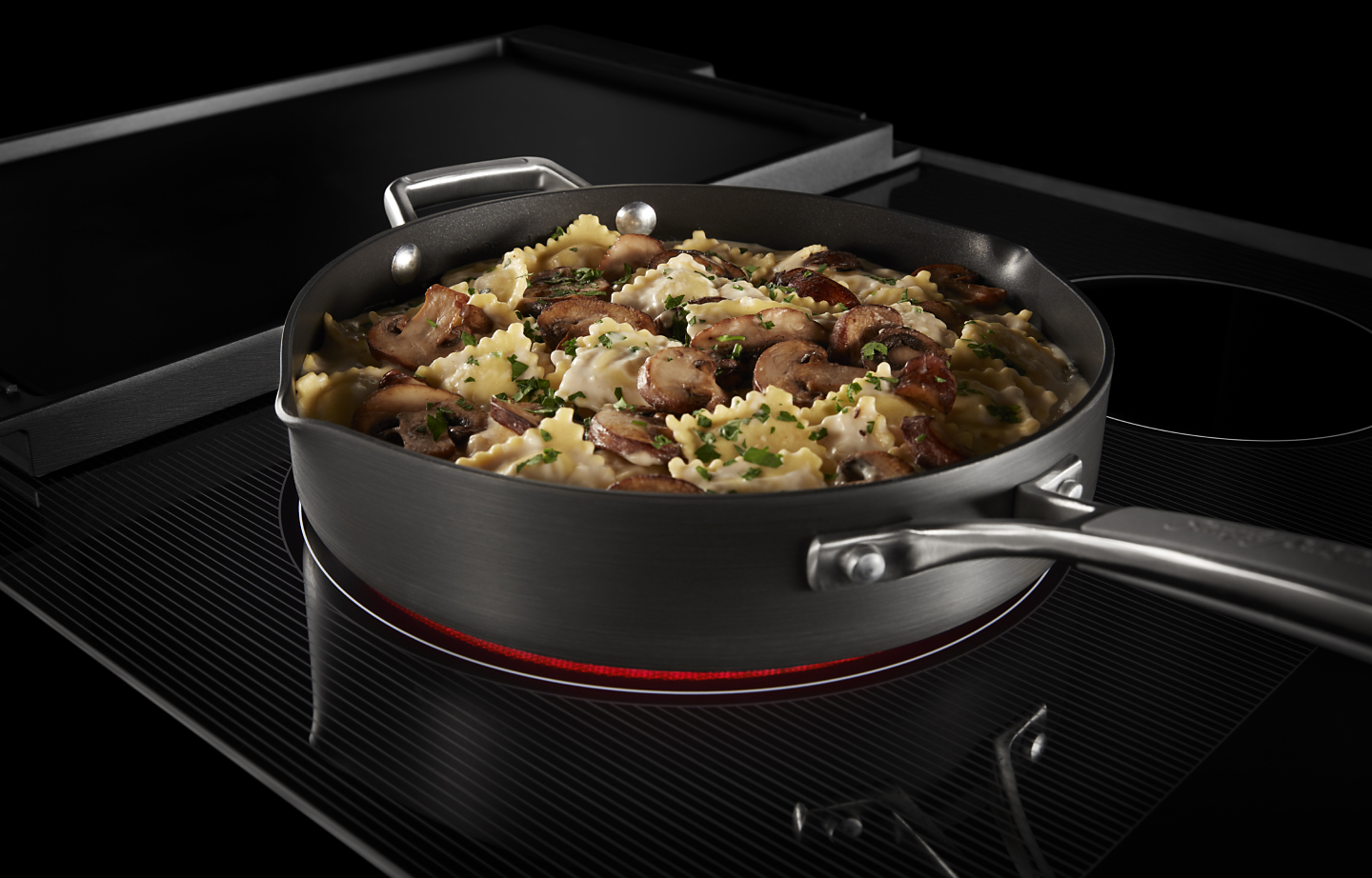 Dinner cooking on a KitchenAid®  induction cooktop.