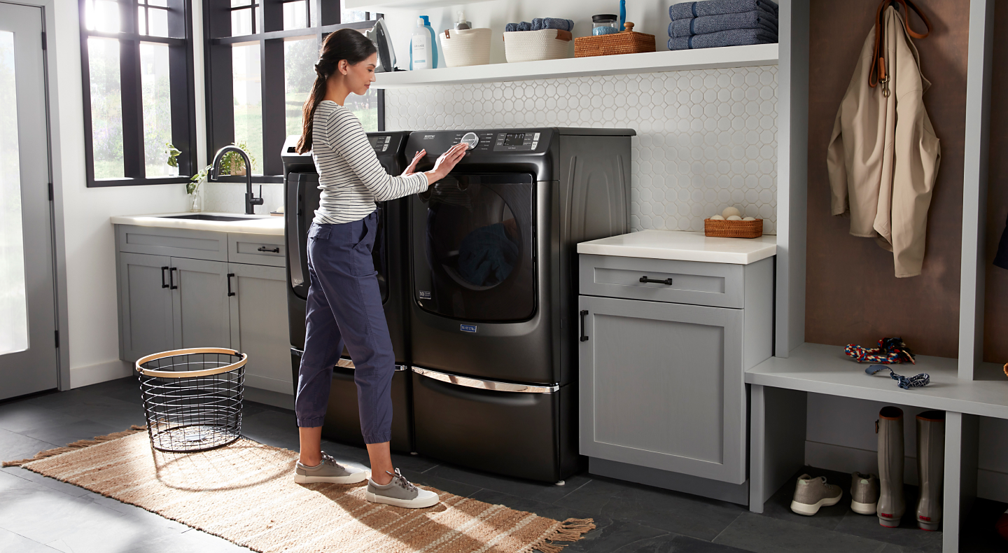 Person selecting a cycle on a Maytag® dryer