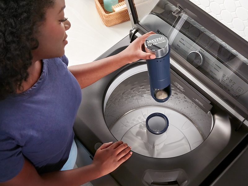 Woman removing a Maytag® agitator from a top load washer