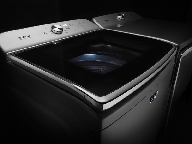 Maytag® stainless steel top load washing machine against black background Maytag® stainless steel top load washing machine against black background