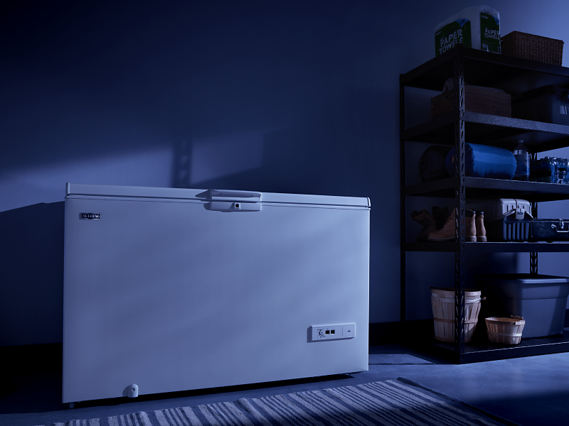 A white Maytag® chest freezer in a dark room A white Maytag® chest freezer in a dark room