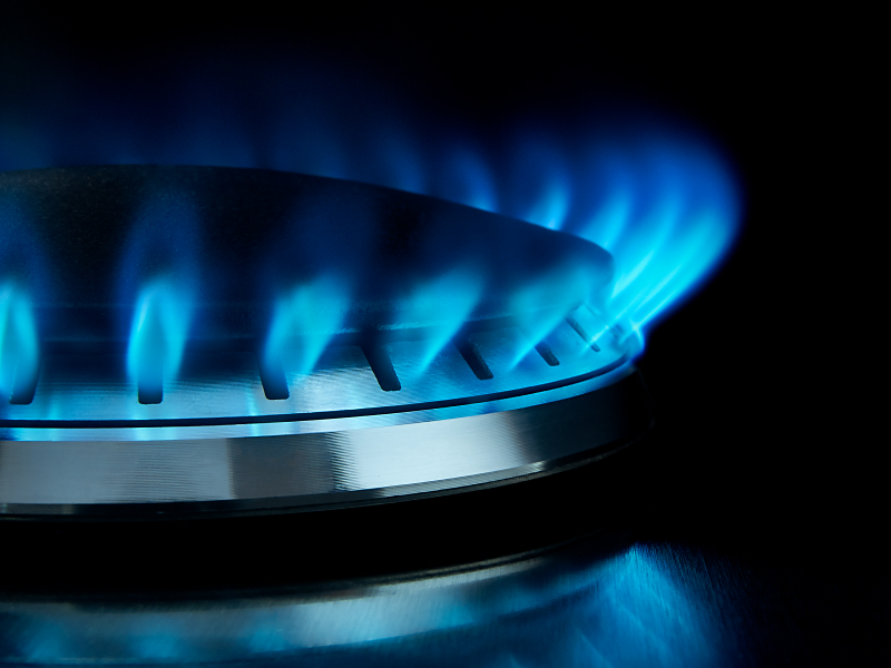 Close-up of blue flames on gas stovetop burners