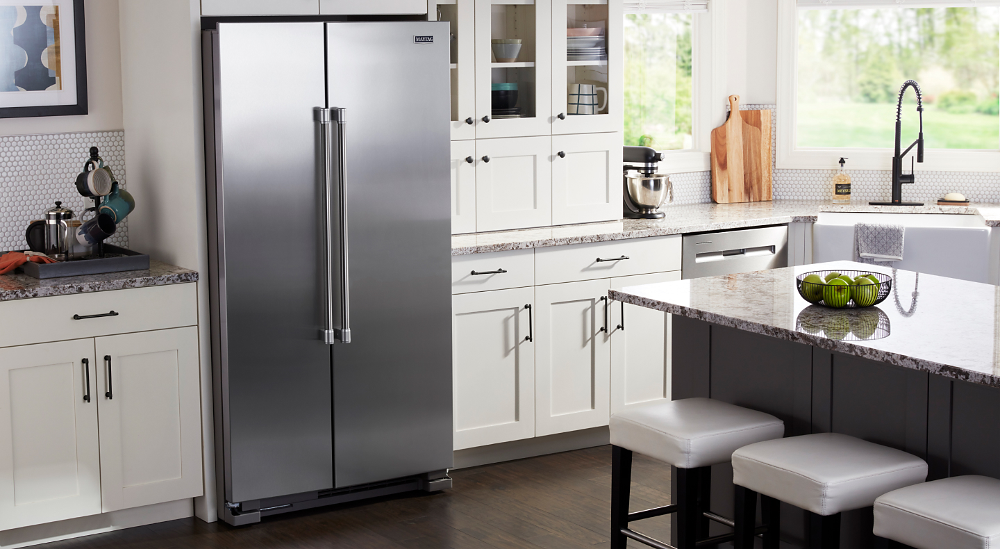 Stainless steel side-by-side Maytag® refrigerator built into white cabinets