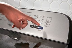A person pressing the Pet Pro Option on a Maytag® washer.
