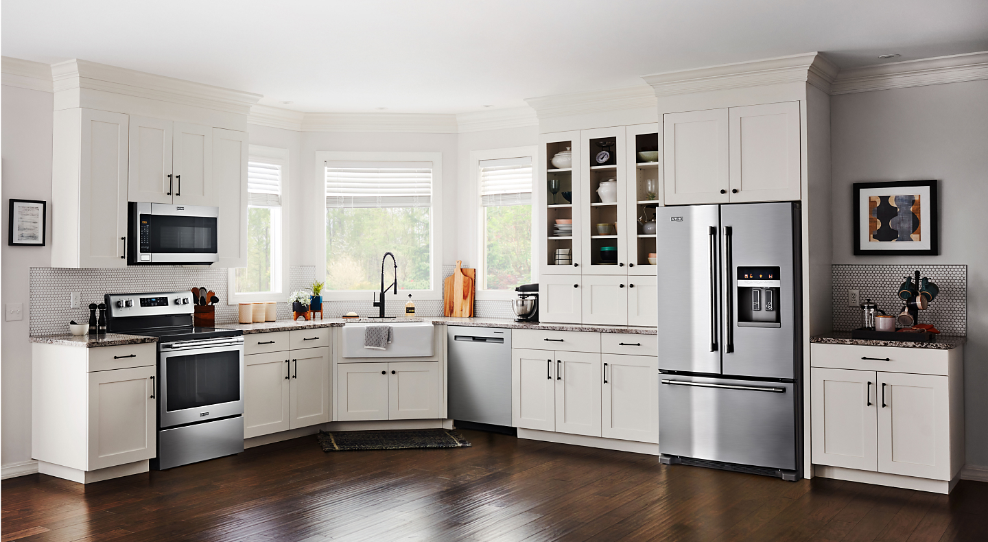 Modern kitchen with white cabinets and stainless steel Maytag® appliances