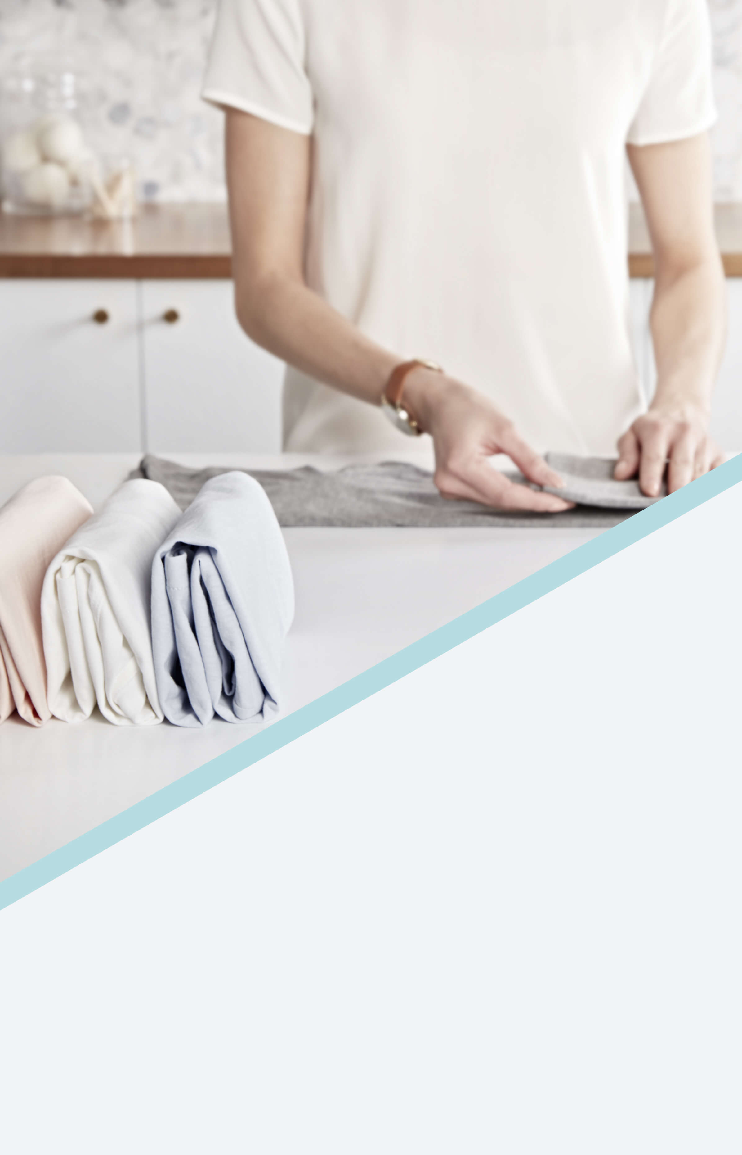 Woman folding laundry on a white countertop