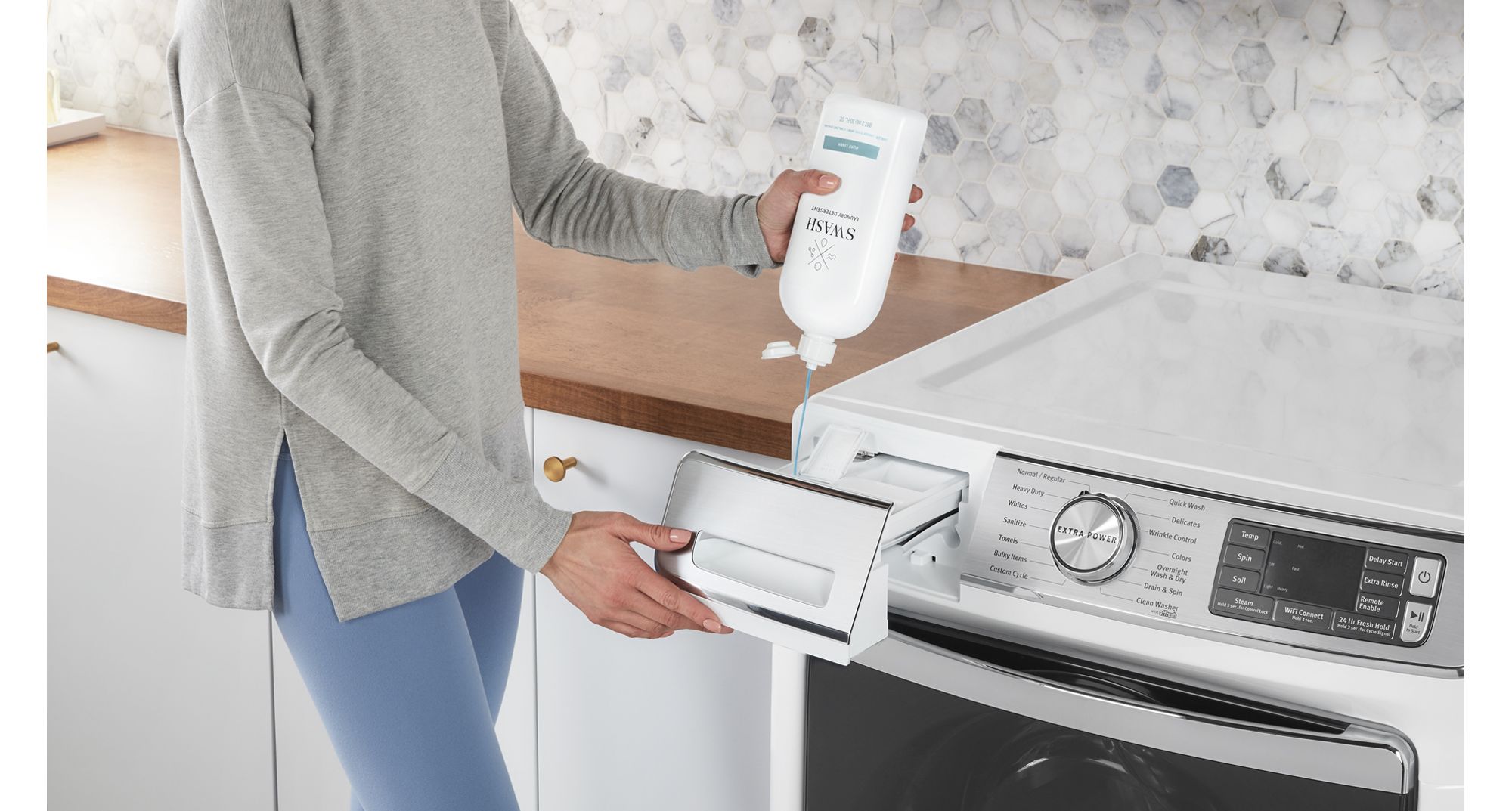 A person pours Swash detergent into the dispenser of a front load washing machine.