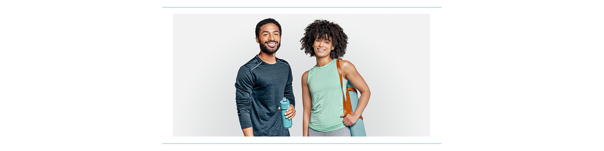 Two people wearing workout clothes and carrying workout gear.