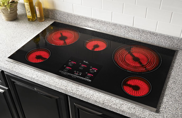 Whirlpool Electric Cooktop Range With Burners On Installed In Grey Counter