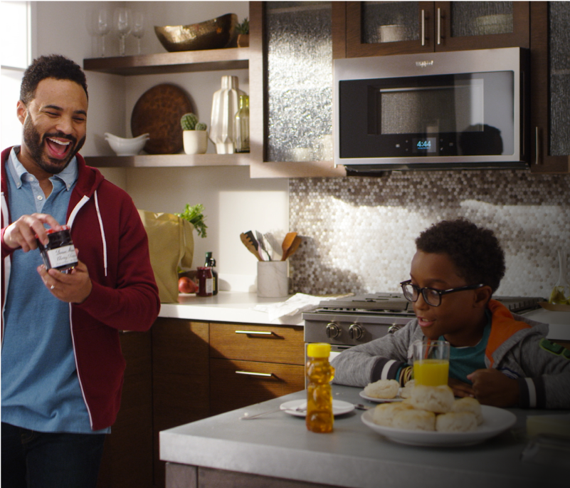 A multi-generational family eating biscuits in the kitchen, with the home heartbeat appliance blog logo