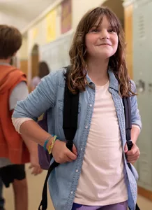 A smiling child in a school hallway