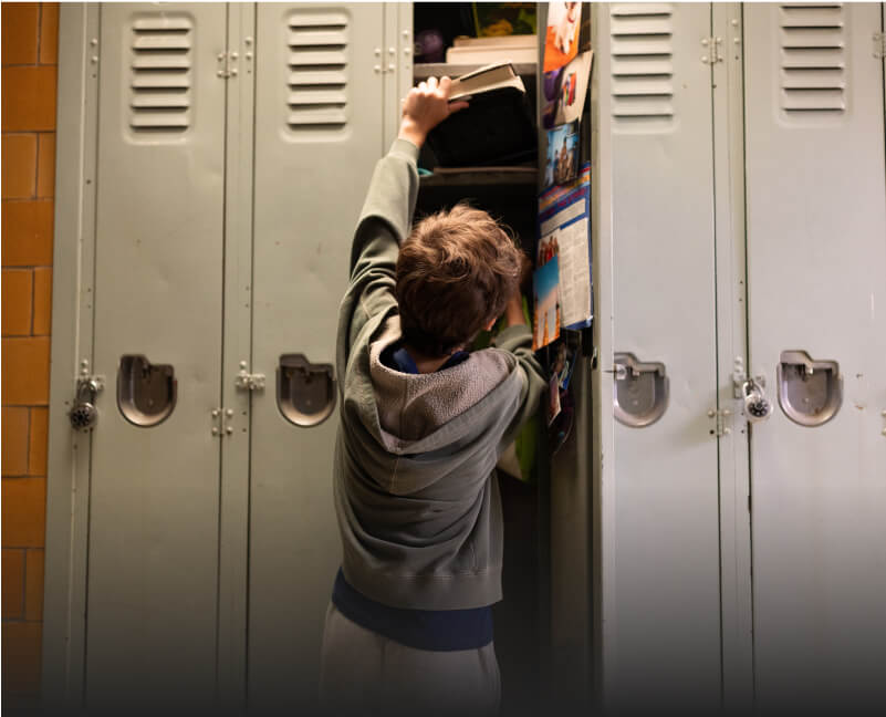 A child reaching for a book in a locker