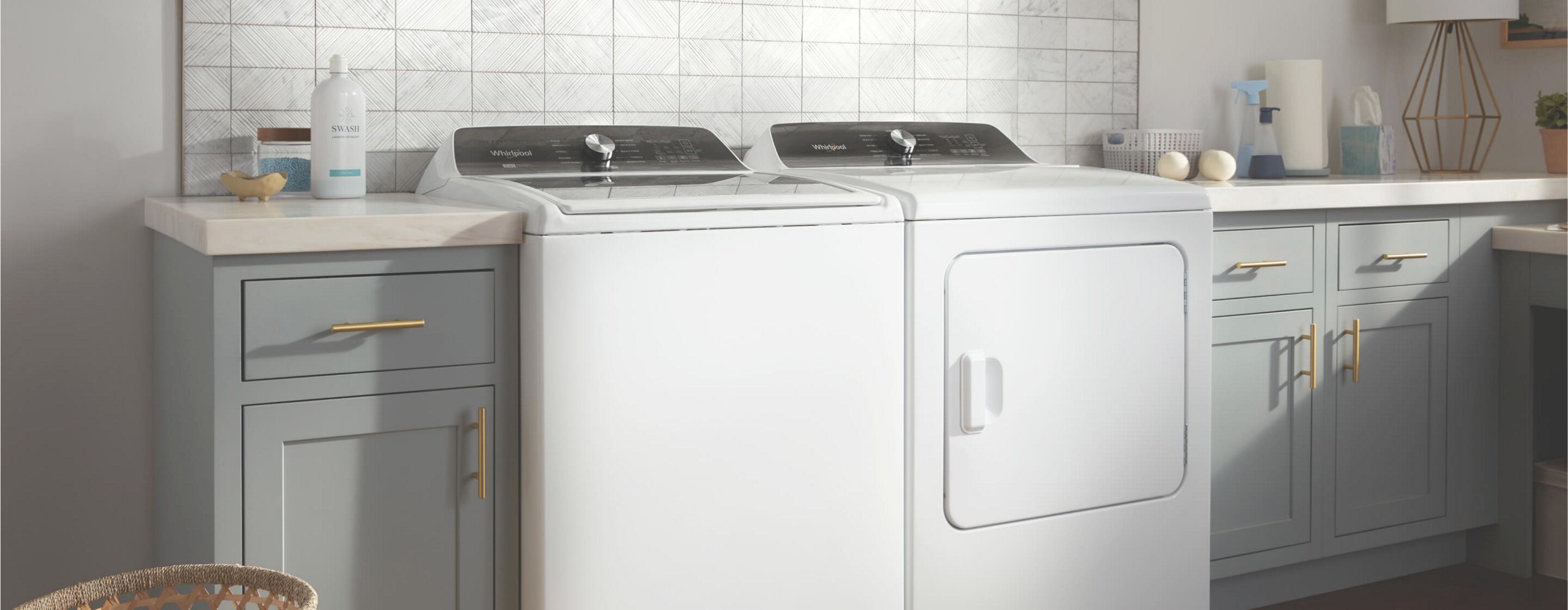 A white top load washer and dryer set in a laundry room