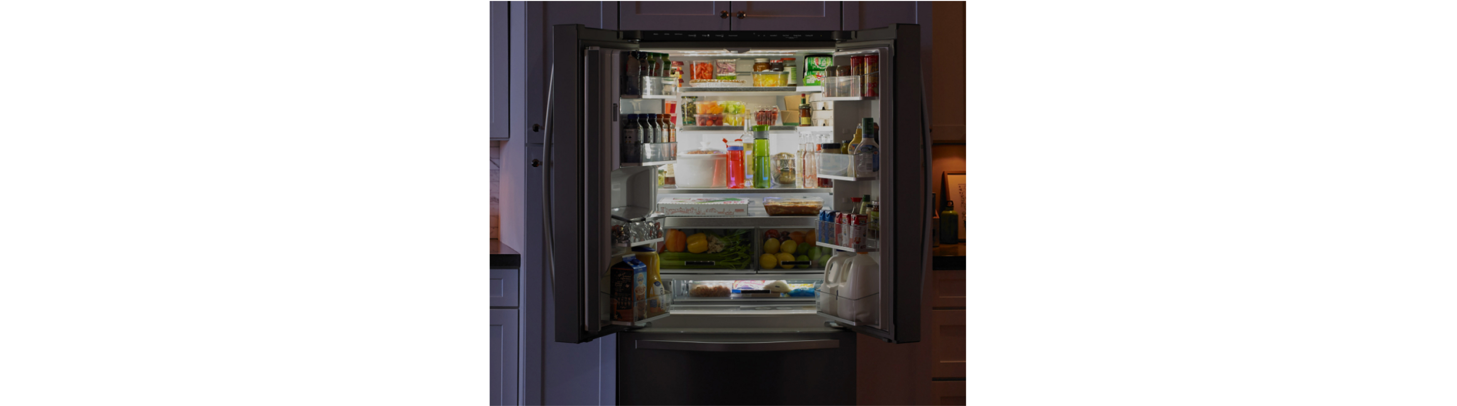 An open counter-depth refrigerator stocked with food and drinks