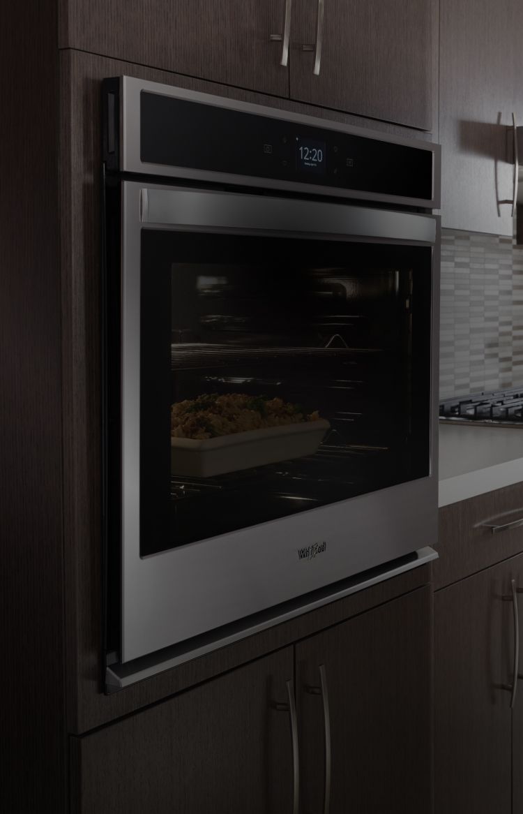 A Whirlpool® kitchen appliance suite featuring the low-profile microwave hood combination.